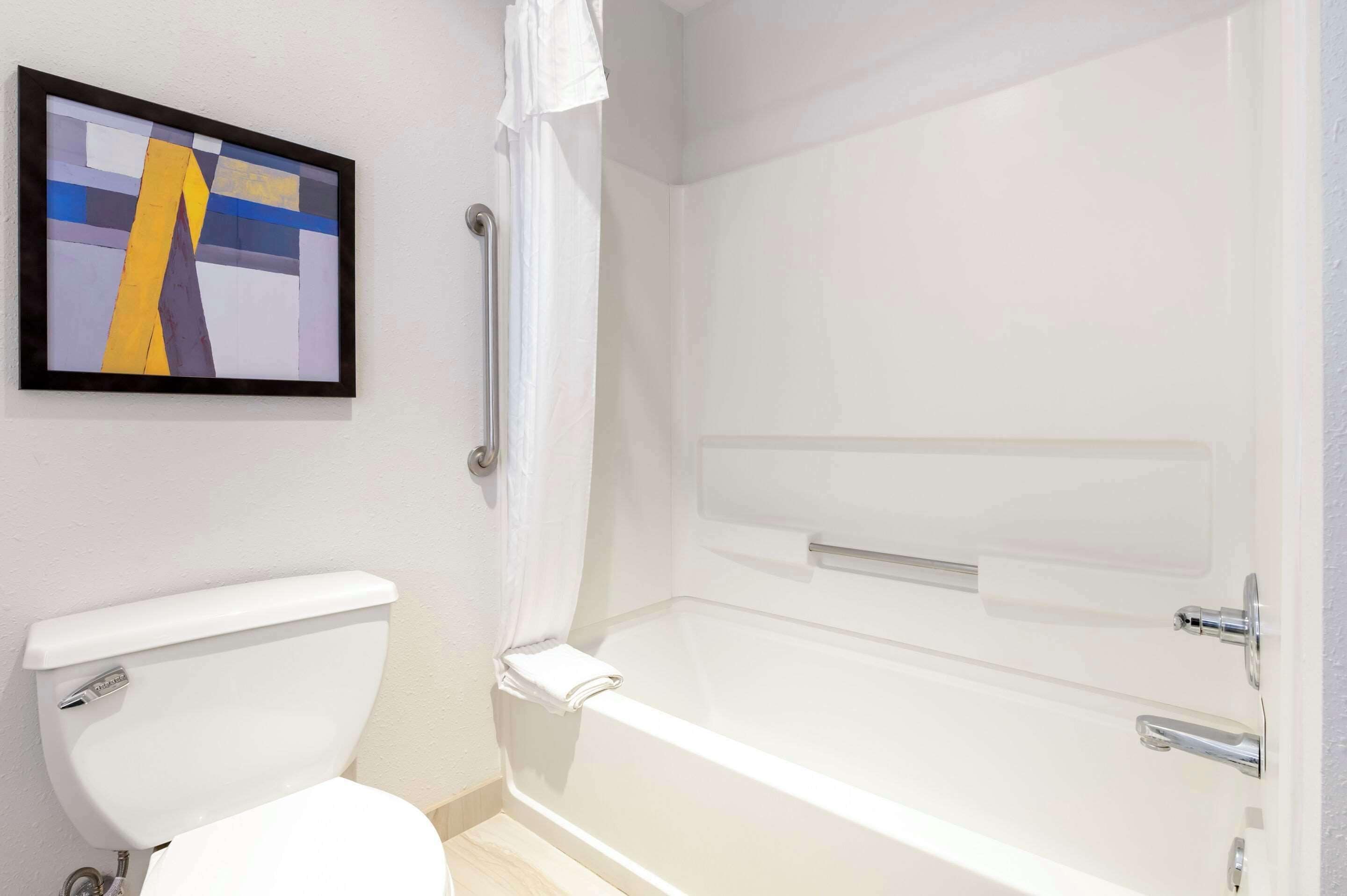 Un baño con inodoro, bañera y cortina de ducha.