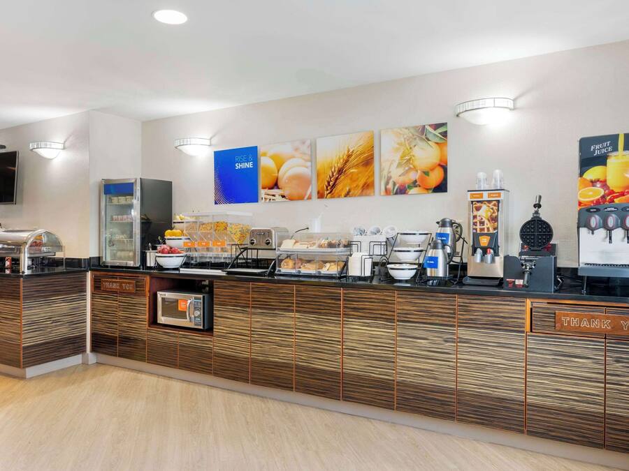 En morgenmadsbuffet med et udvalg af mad, en kaffemaskine og en juiceautomat.
