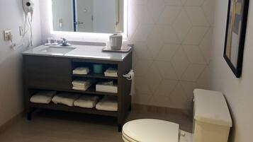 A bathroom with a toilet, sink, and mirror.