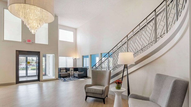 A spacious lobby with a modern staircase, a chandelier, and seating area. - Comfort Inn Edinburgh - Columbus (Edinburgh)