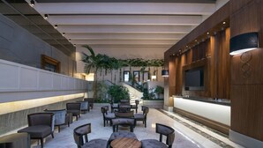 Un vestíbulo con área de descanso, una recepción y una escalera.