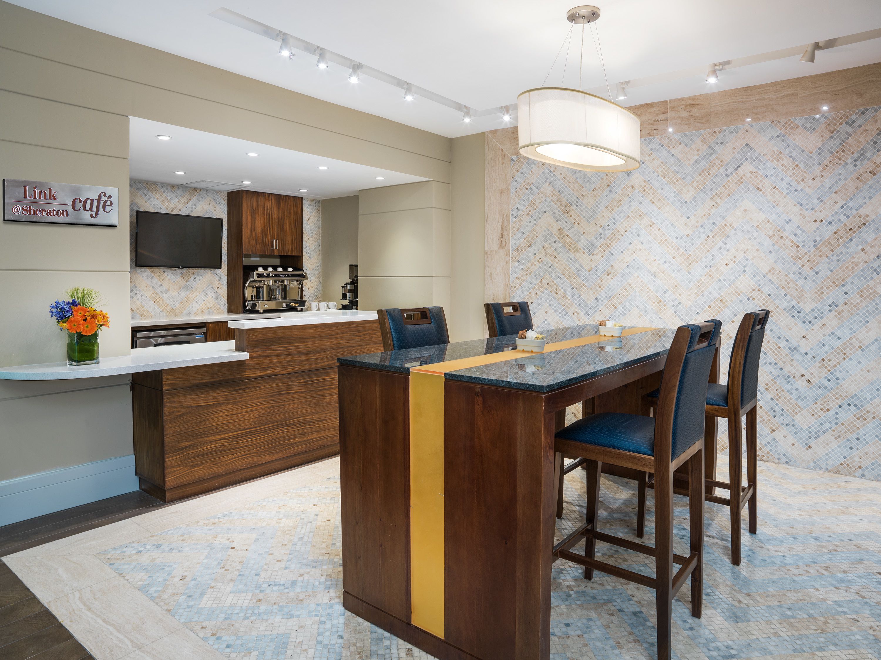 A modern kitchen with a central island, bar area, and seating.