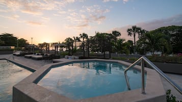 Alberca al aire libre, sombrillas en la alberca y camastros