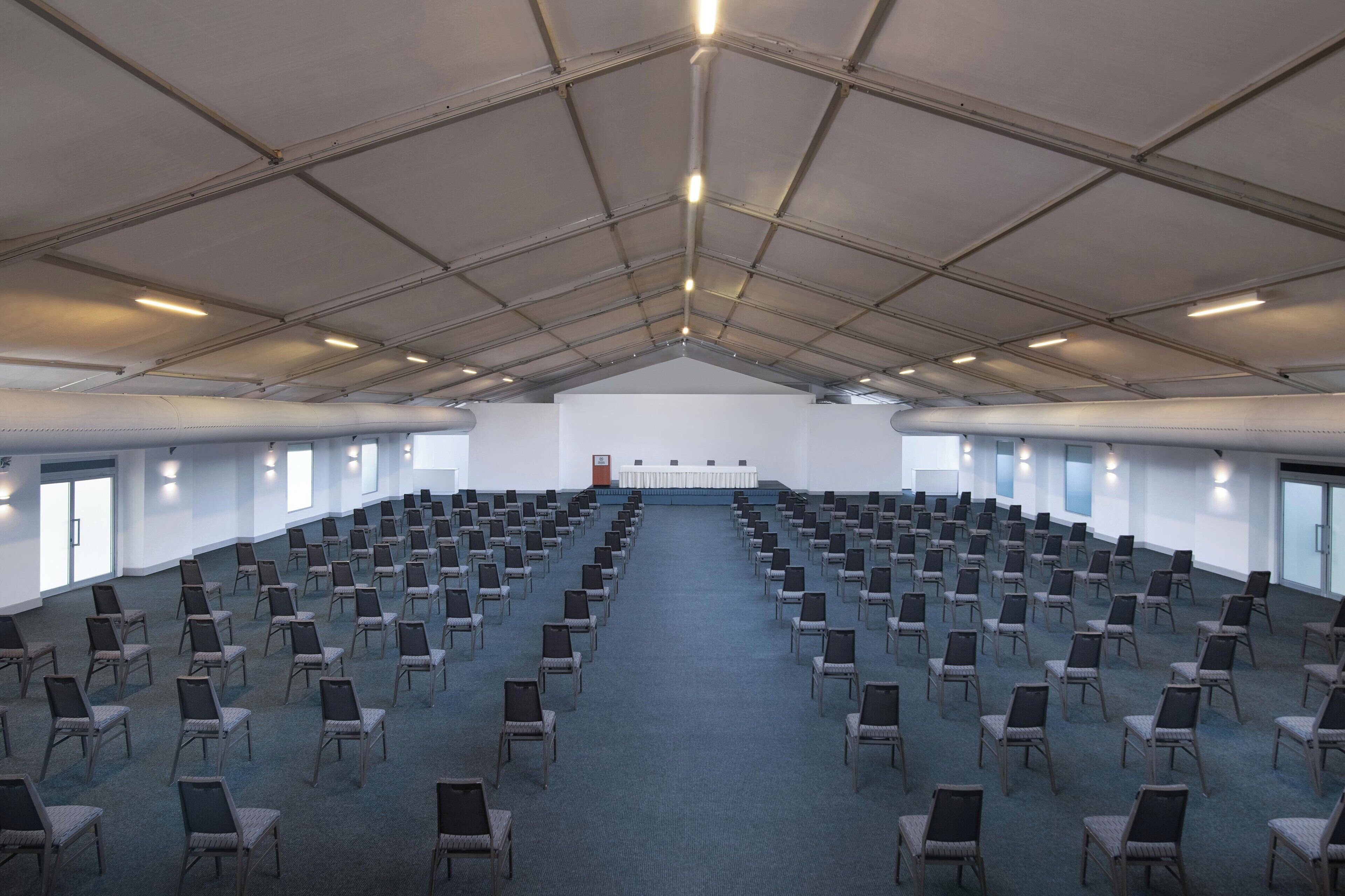 A large hall with rows of chairs arranged for an event.