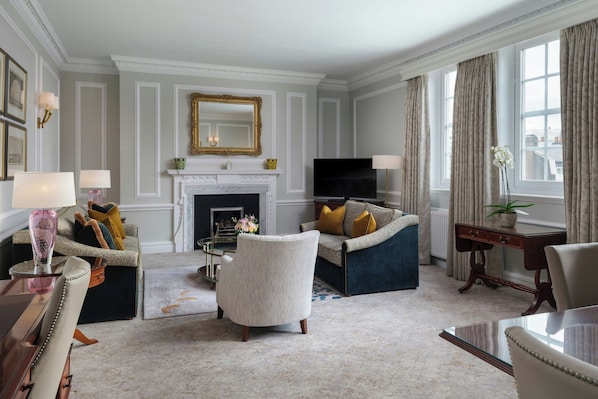 A living room with a fireplace, a television, and a sofa. - 47 Park Street - Grand Residences by Marriott (London)
