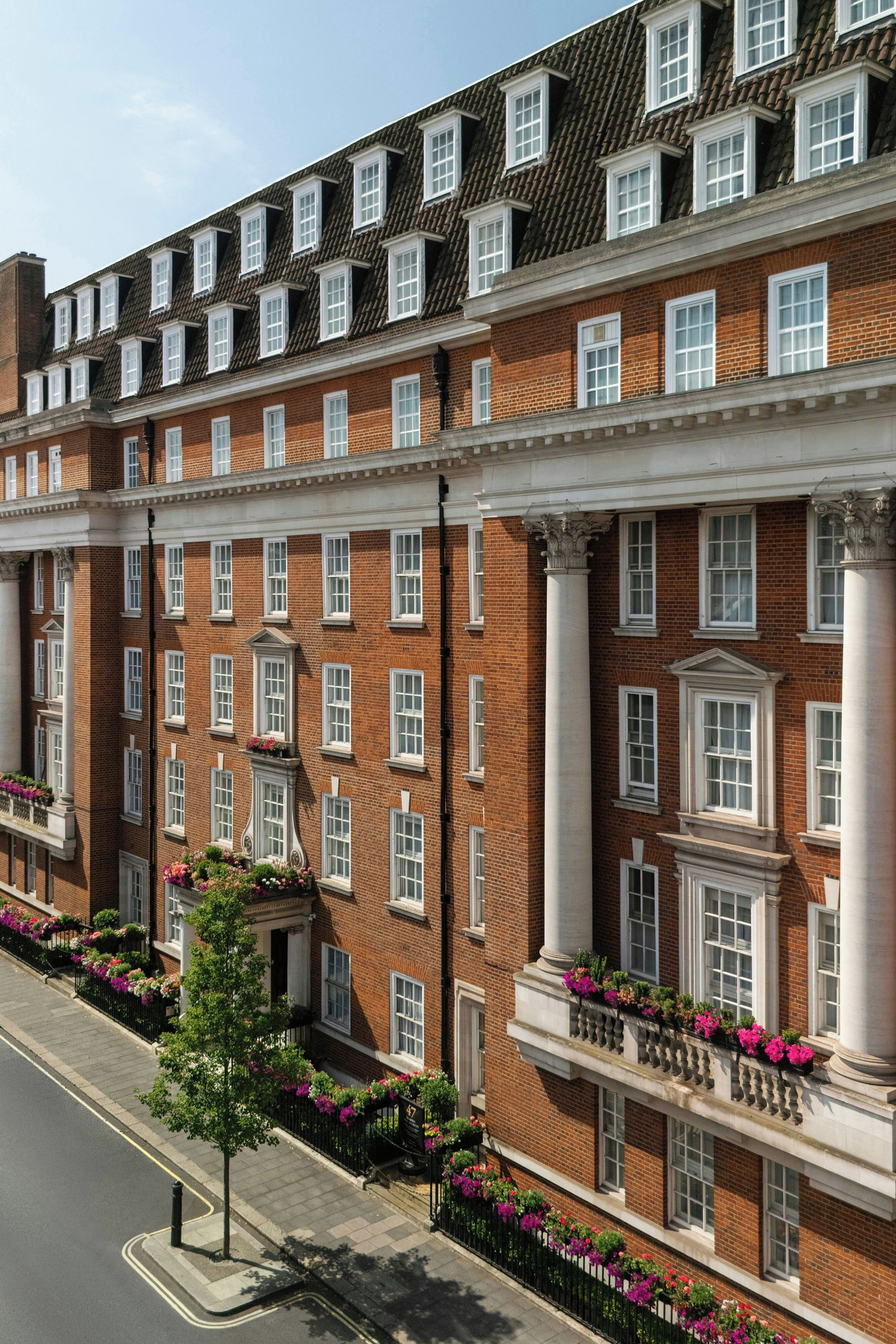 A multi-story brick building with uniform windows and a central entrance with columns.