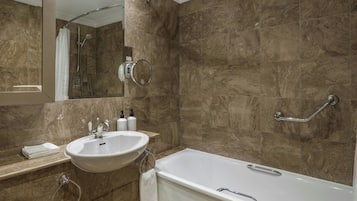 A bathroom with a sink, mirror, shower, and bathtub.