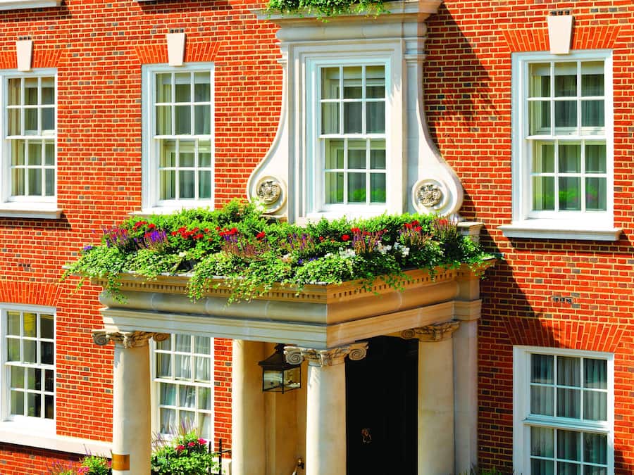 A red brick building with white-framed windows and a central entrance with a decorative column.