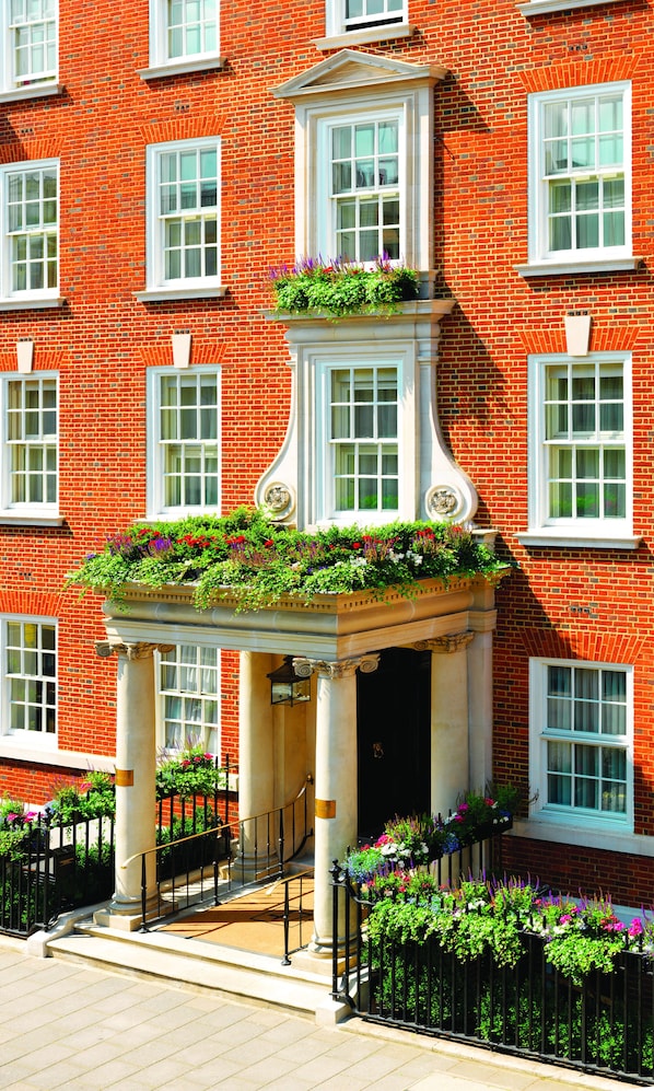 A red brick building with white-framed windows and a central entrance with a decorative column.