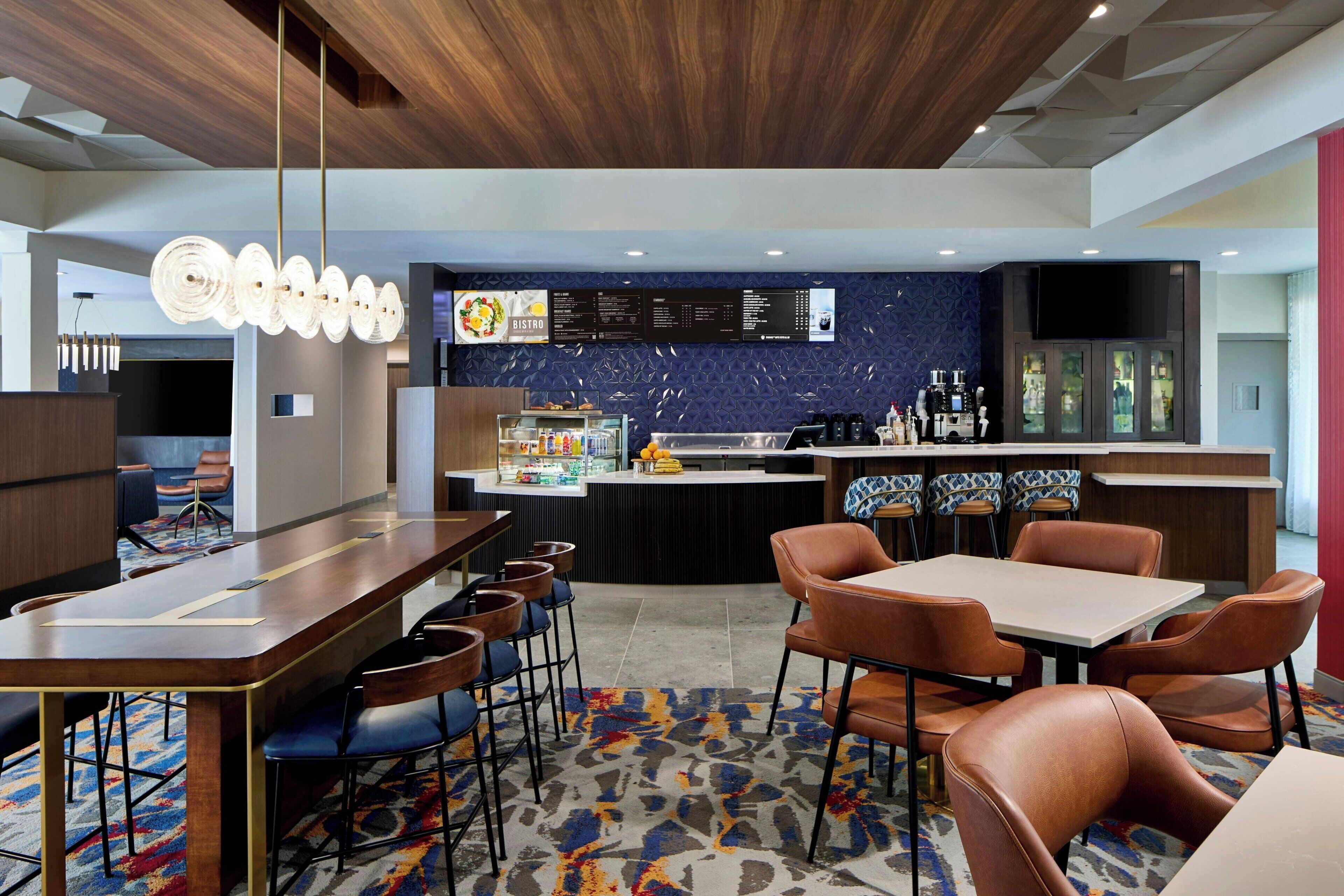 A modern bistro with a bar area, seating arrangements, and a menu display.