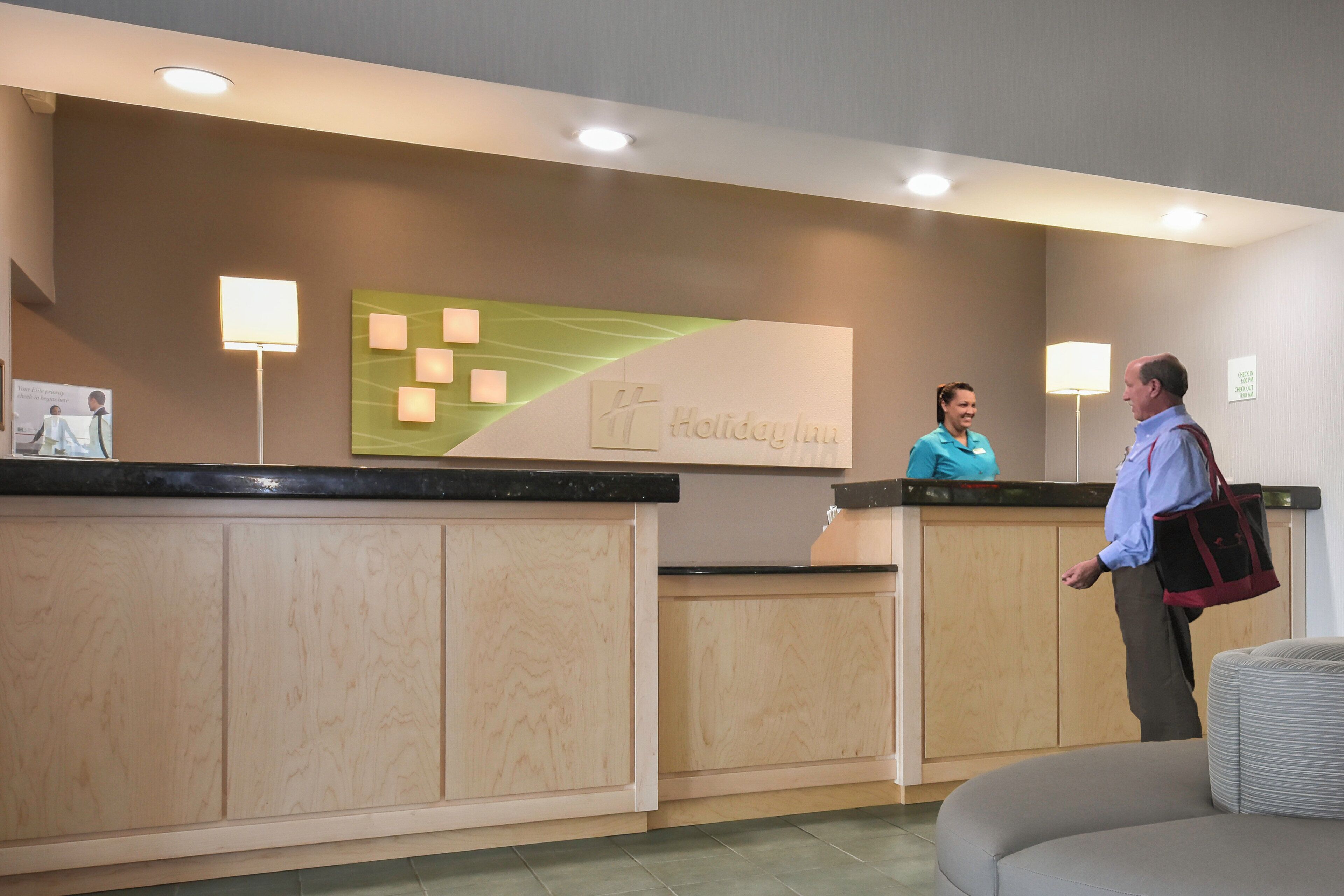 A reception desk with a sign reading 'Holiday Inn' and a counter with a lighted sign.