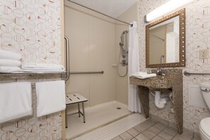 Enjoy a refreshing shower and get ready in style with a spacious vanity featuring a sink, mirror, and toilet.