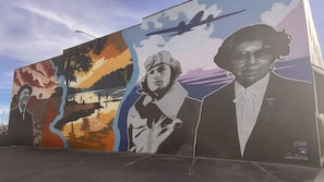 A mural with multiple figures and a plane.