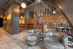 Un interno moderno con un'area bar, posti a sedere e pannelli decorativi in legno.