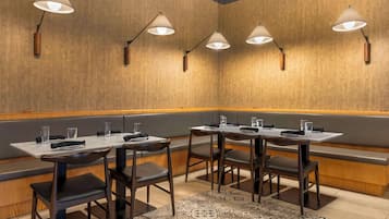 Un restaurante con mesasychairs, paredes de madera e iluminación colgante.