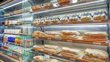 A deli counter with various sandwiches, salads, and beverages.