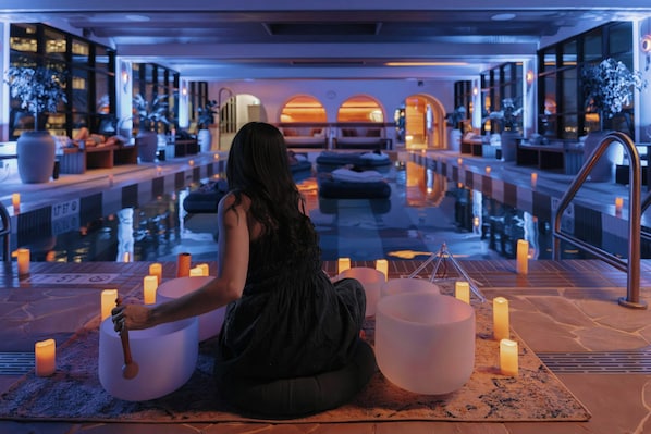 Un espace spa comprenant une piscine, des sièges et des bougies.