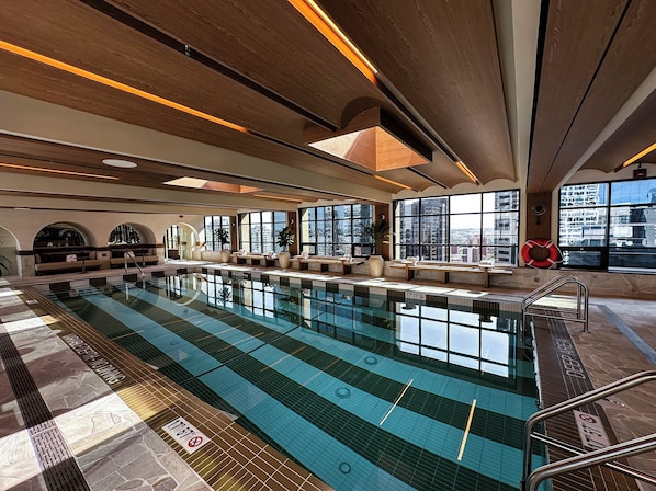 Una piscina cubierta, tumbonas