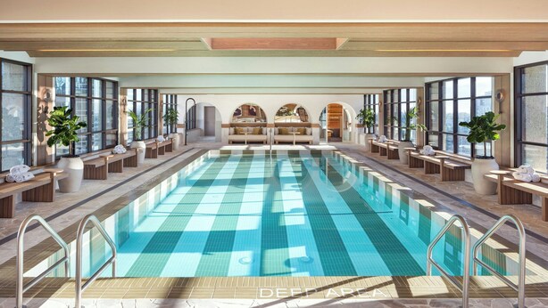A large indoor swimming pool with clear blue tiles, surrounded by seating areas and large windows. - The Westin Calgary (Calgary)