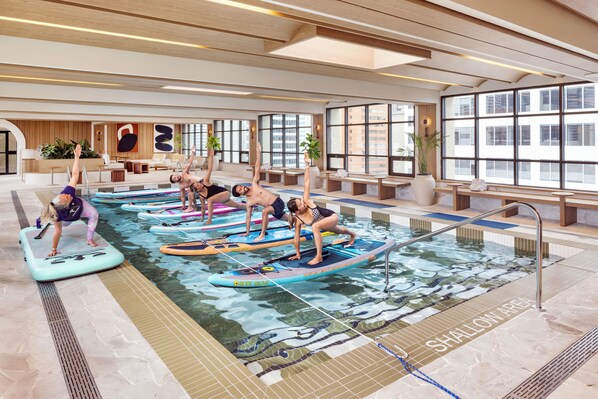Un espace piscine doté de plusieurs toboggans et de chaises longues.