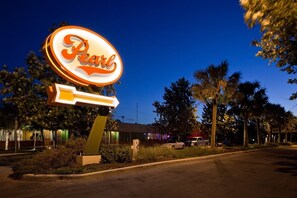 A neon sign for 'Pearl' with a directional arrow, palm trees, and a building in the background. - Marriott San Antonio Riverwalk (San Antonio)