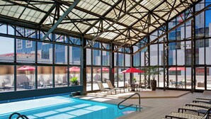 Una piscina cubierta, una piscina al aire libre, sombrillas, tumbonas