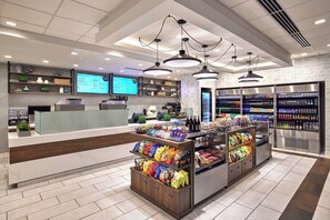 A modern snack bar with a digital menu display, a variety of snacks, and a refrigerated beverage section.