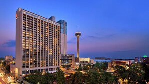 Un hotel moderno de gran altura con una torre destacada y fachada de vidrio.