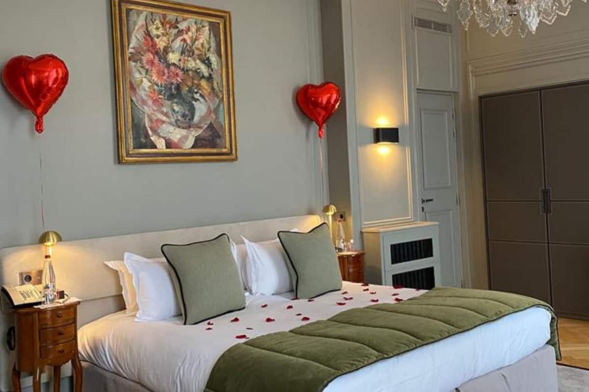 Habitación de hotel con una cama grande, dos mesitas de noche, un armario y un cuadro en la pared.