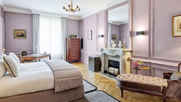 Une chambre à coucher comprenant un lit, une commode, une chaise, une cheminée et un grand miroir.