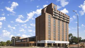 A multi-story hotel with a prominent 'BIRCHWOOD INN' sign, featuring a modern brick facade and a flat roof.