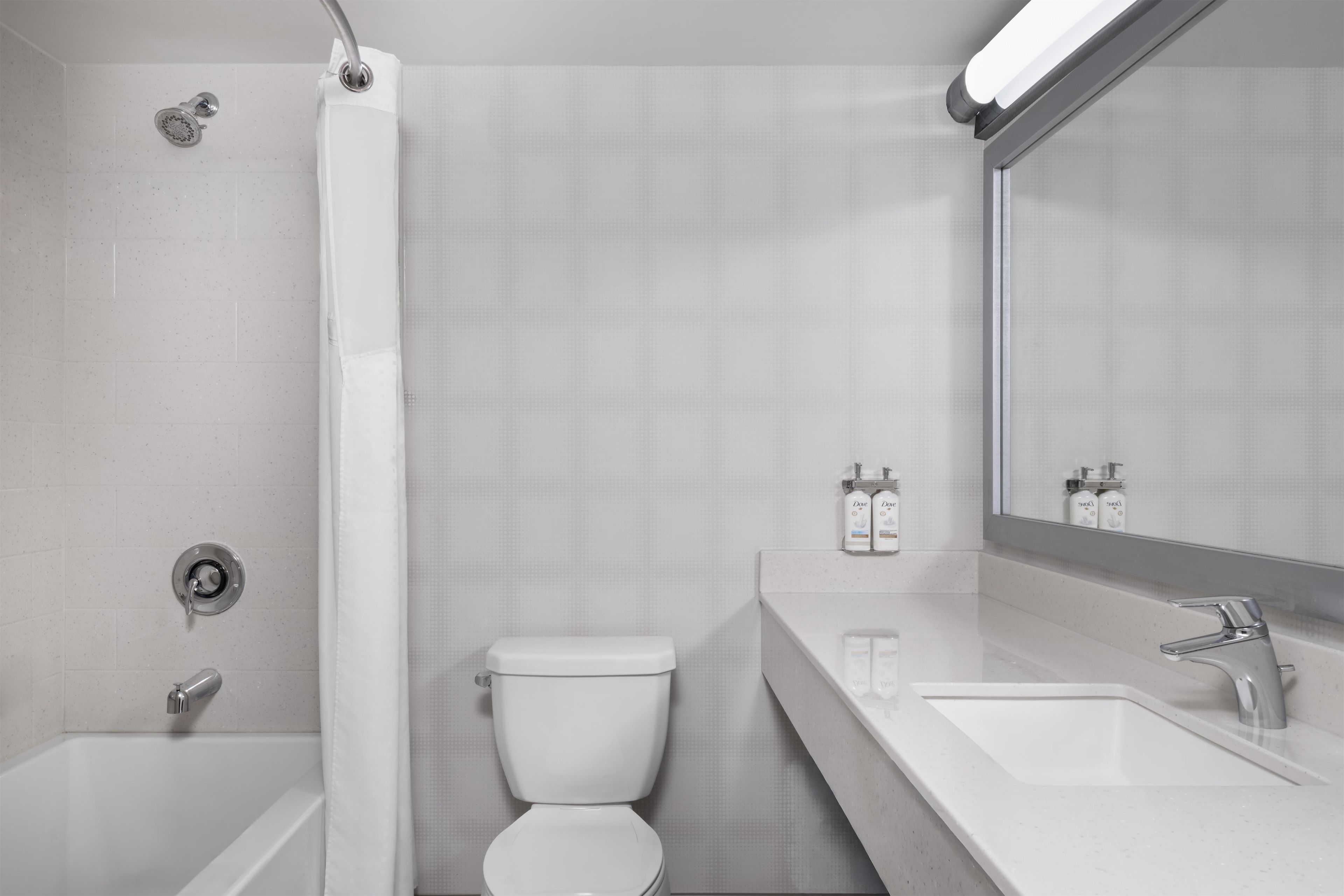 A modern bathroom with a bathtub, toilet, and sink.