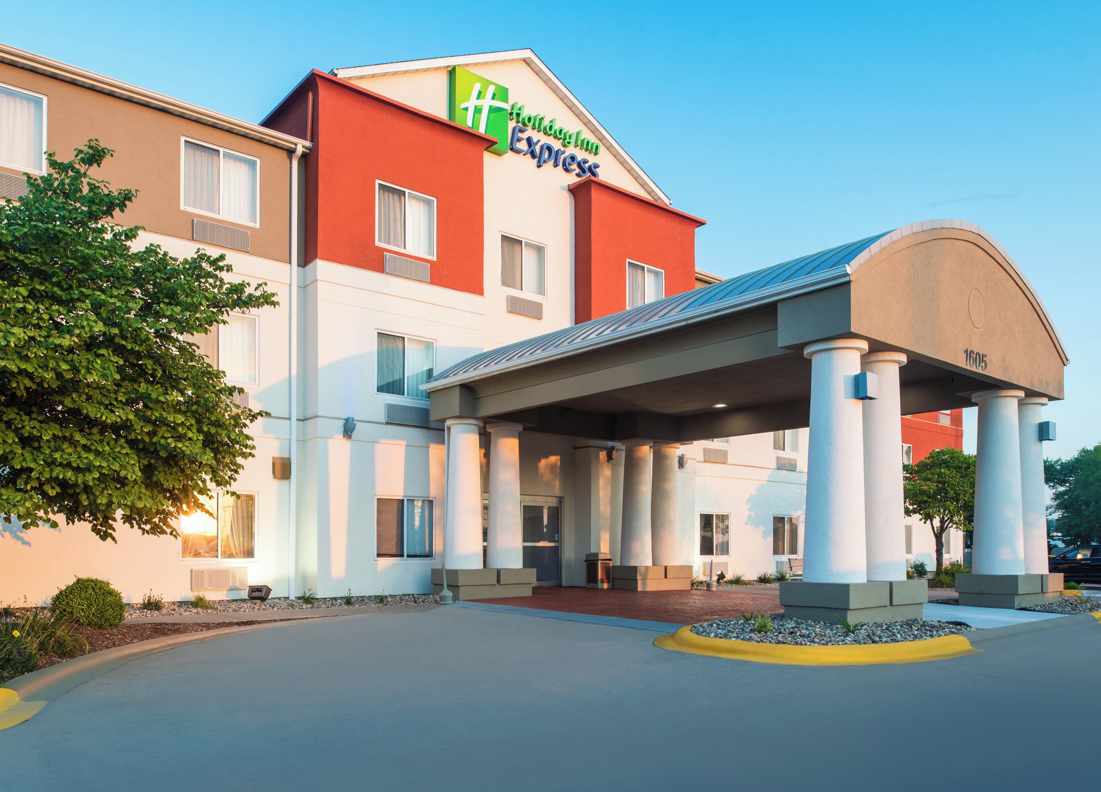 Un hotel con entrada cubierta, varias ventanas y cielo despejado.