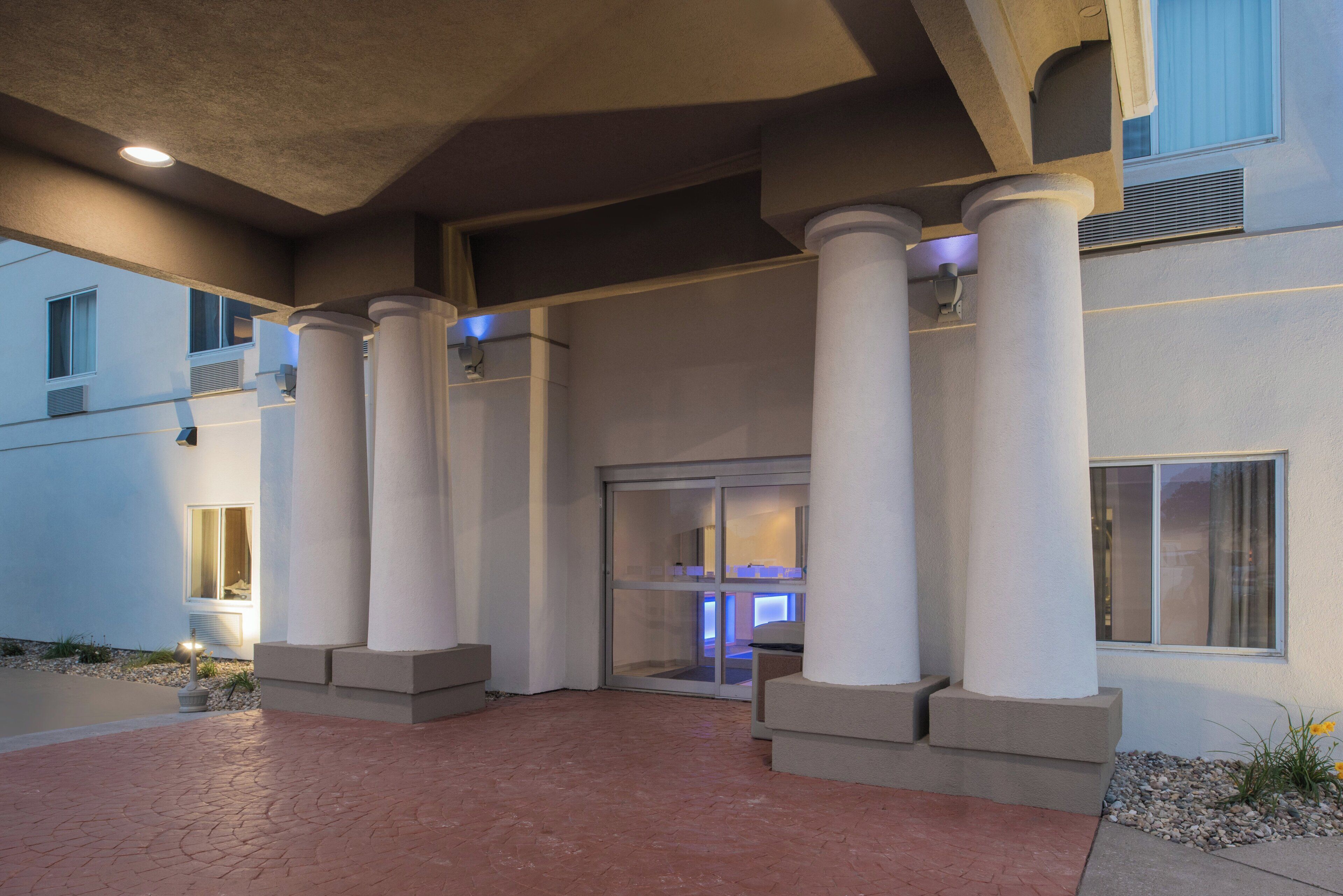 A building entrance with columns, a door, and a window.