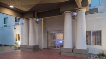 A building entrance with columns, a door, and a window.
