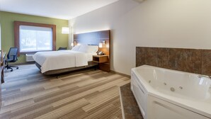 Habitación de hotel con cama, escritorio, silla, ventana y bañera.