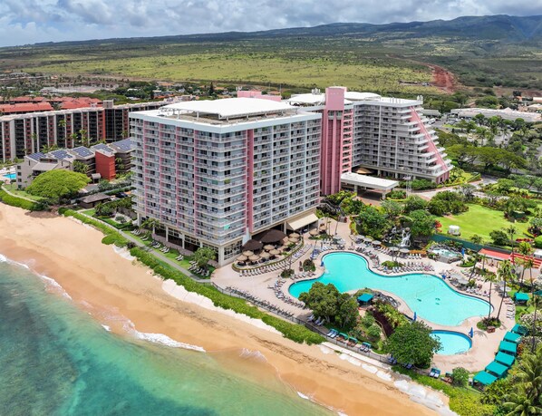 A resort with multiple high-rise buildings, a beachfront, and a large swimming pool with sun loungers. - Hilton Vacation Club Ka'anapali Beach Maui (Kaanapali)