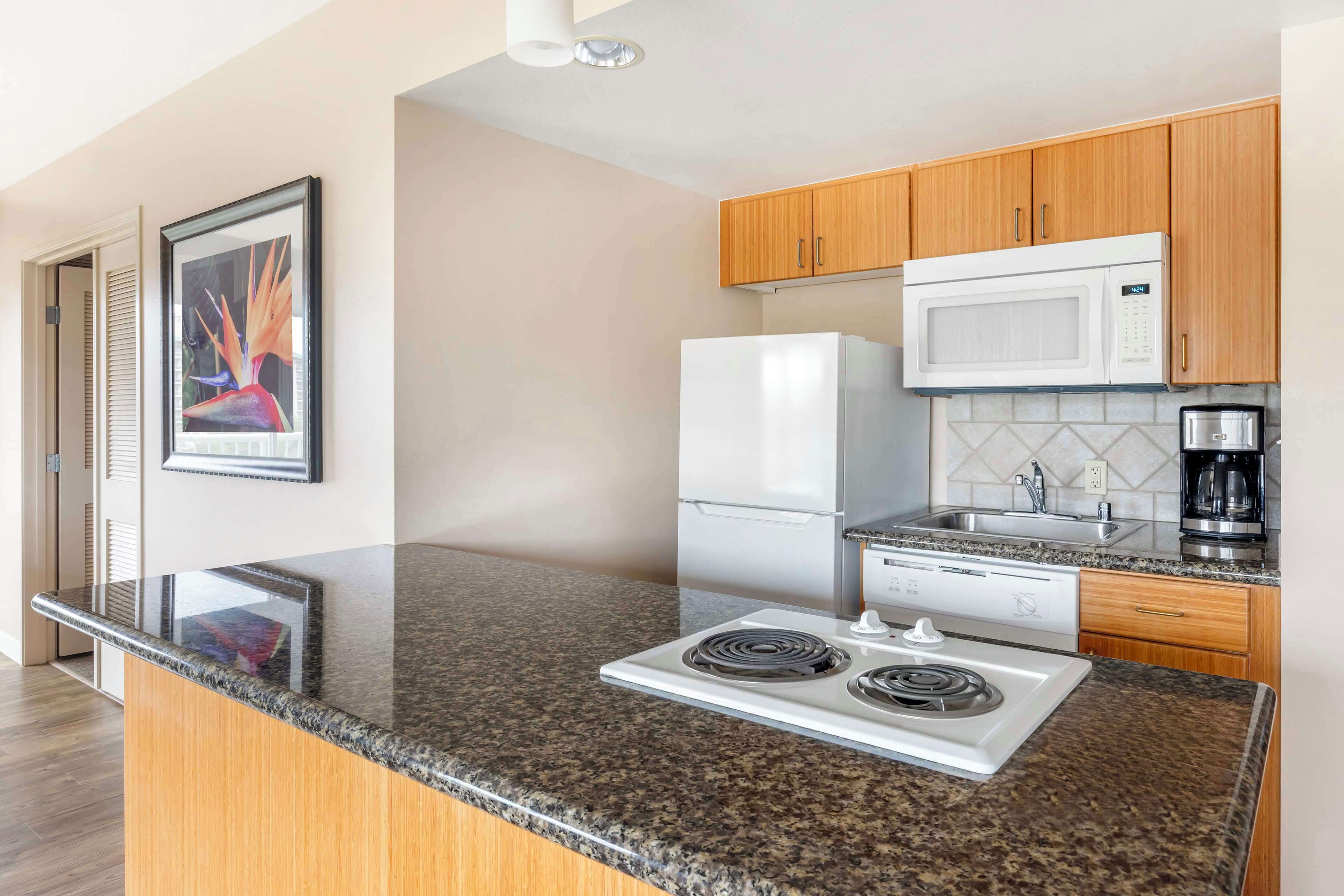 A modern kitchen with granite countertops, stainless steel appliances, and wooden cabinets.
