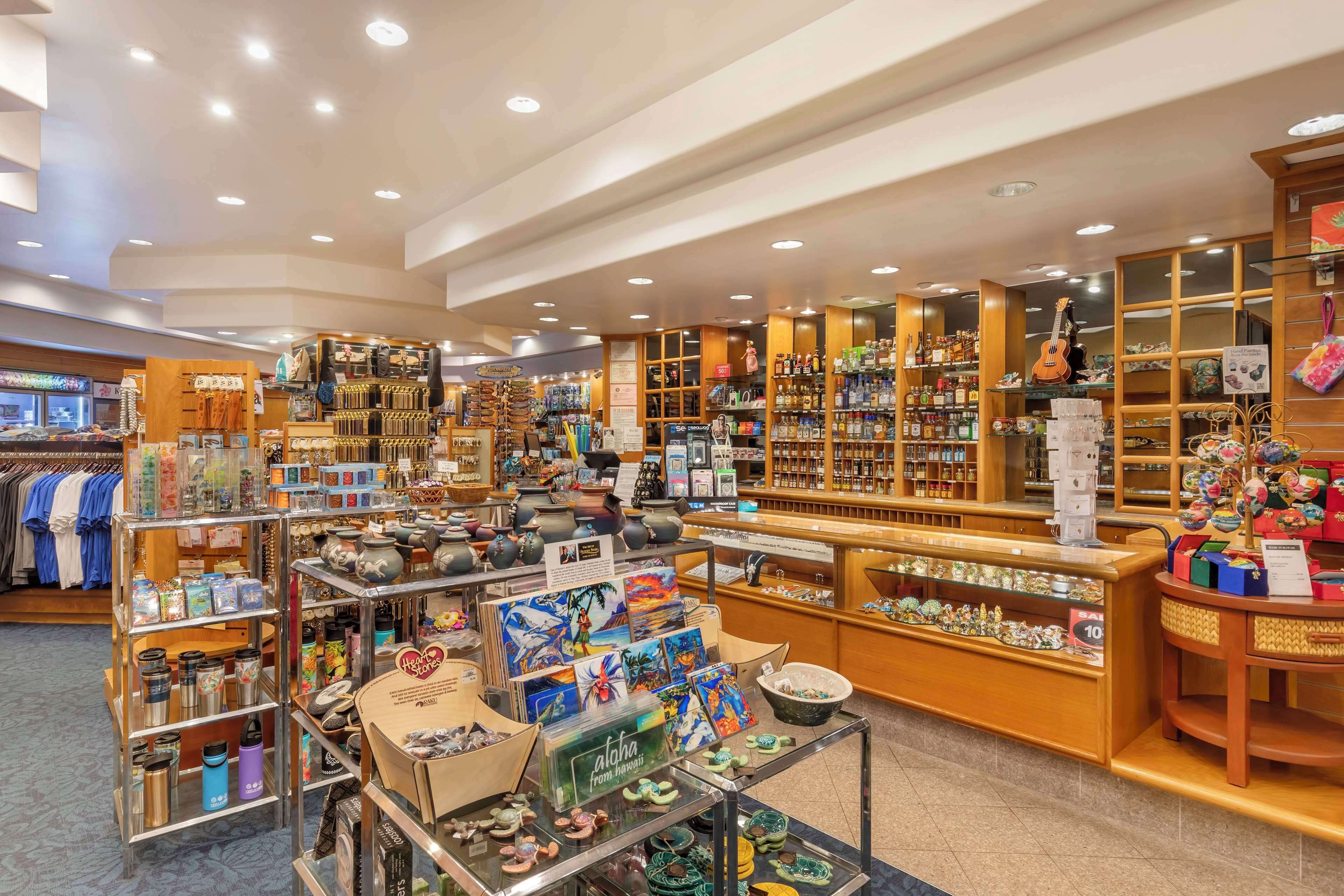 A well-lit retail store with various products on display, including ceramics, clothing, and souvenirs.