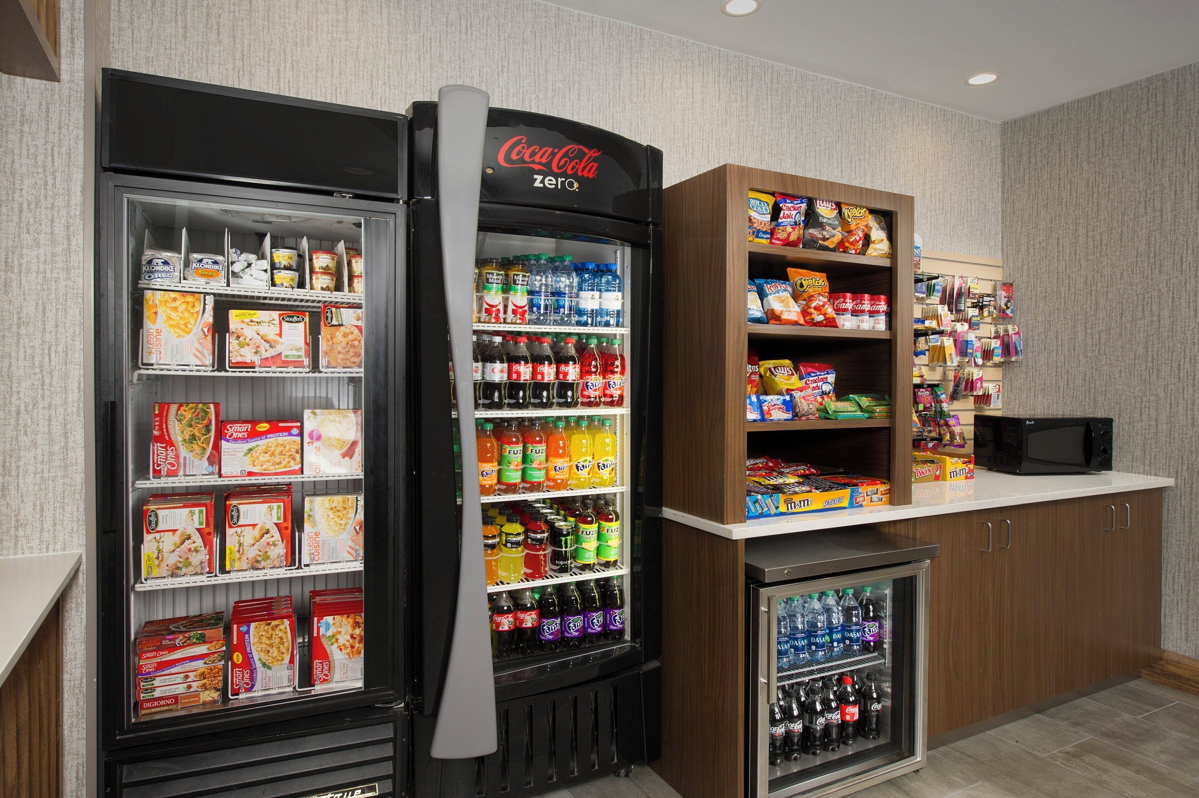 Un espace équipé de distributeurs automatiques proposant une variété d’aliments et de boissons, notamment des en-cas, des boissons et des plateaux-repas.