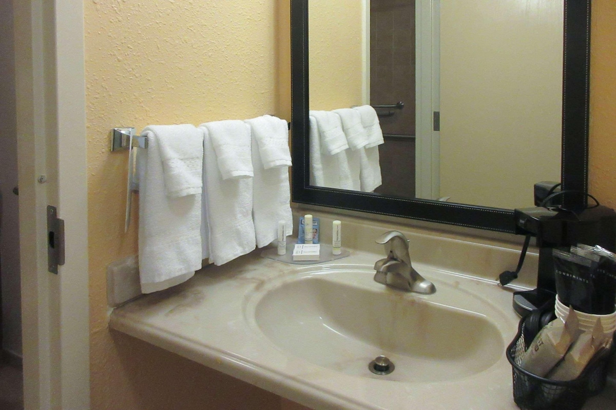 A bathroom with a sink, mirror, and towel rack.
