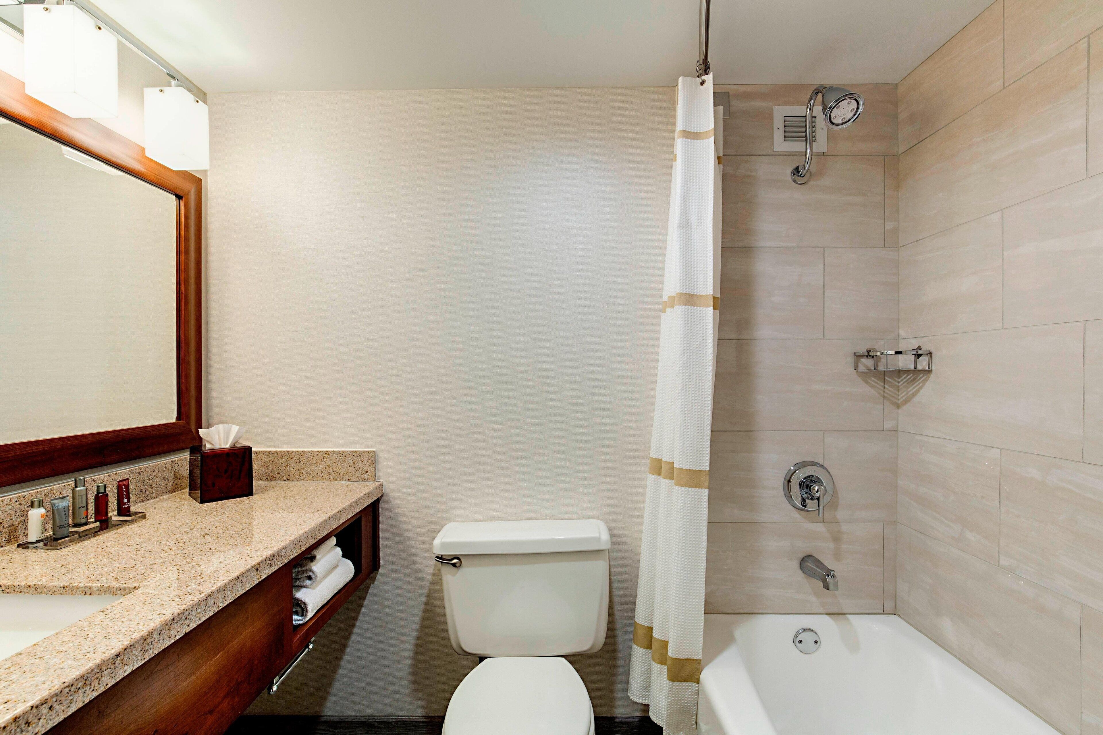 Een badkamer met toilet, wastafel en bad.