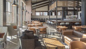 A spacious restaurant with high ceilings, exposed beams, and a variety of seating options including tables, chairs, and sofas. - Lincolnshire Marriott Resort (Lincolnshire)