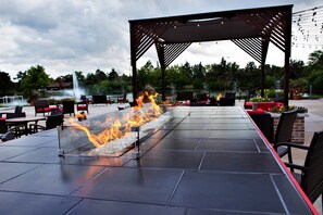 An outdoor patio with a fire feature, seating, and a pergola structure. - Lincolnshire Marriott Resort (Lincolnshire)