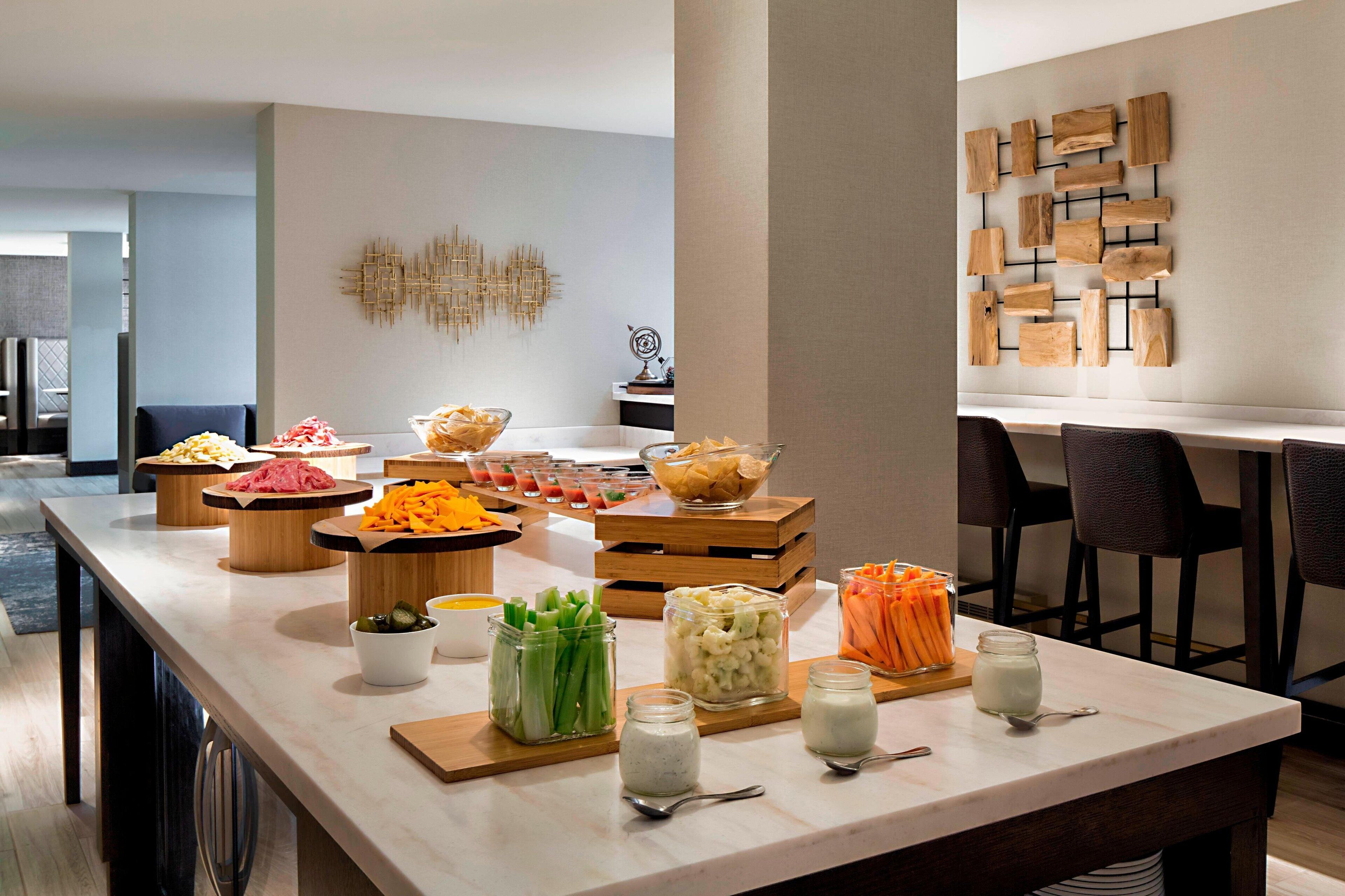 A buffet setup with various food items and utensils on a long table.