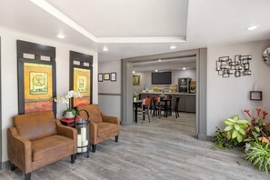 A modern living room with a sofa, a coffee table, and a decorative vase. - Quality Inn Goose Creek - Charleston (Goose Creek)
