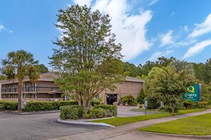 A Quality Inn hotel with a two-story building, a parking lot, and a well-maintained lawn. - Quality Inn Goose Creek - Charleston (Goose Creek)