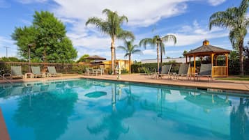 Una piscina al aire libre, tumbonas