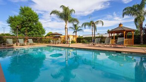 Una piscina al aire libre, tumbonas