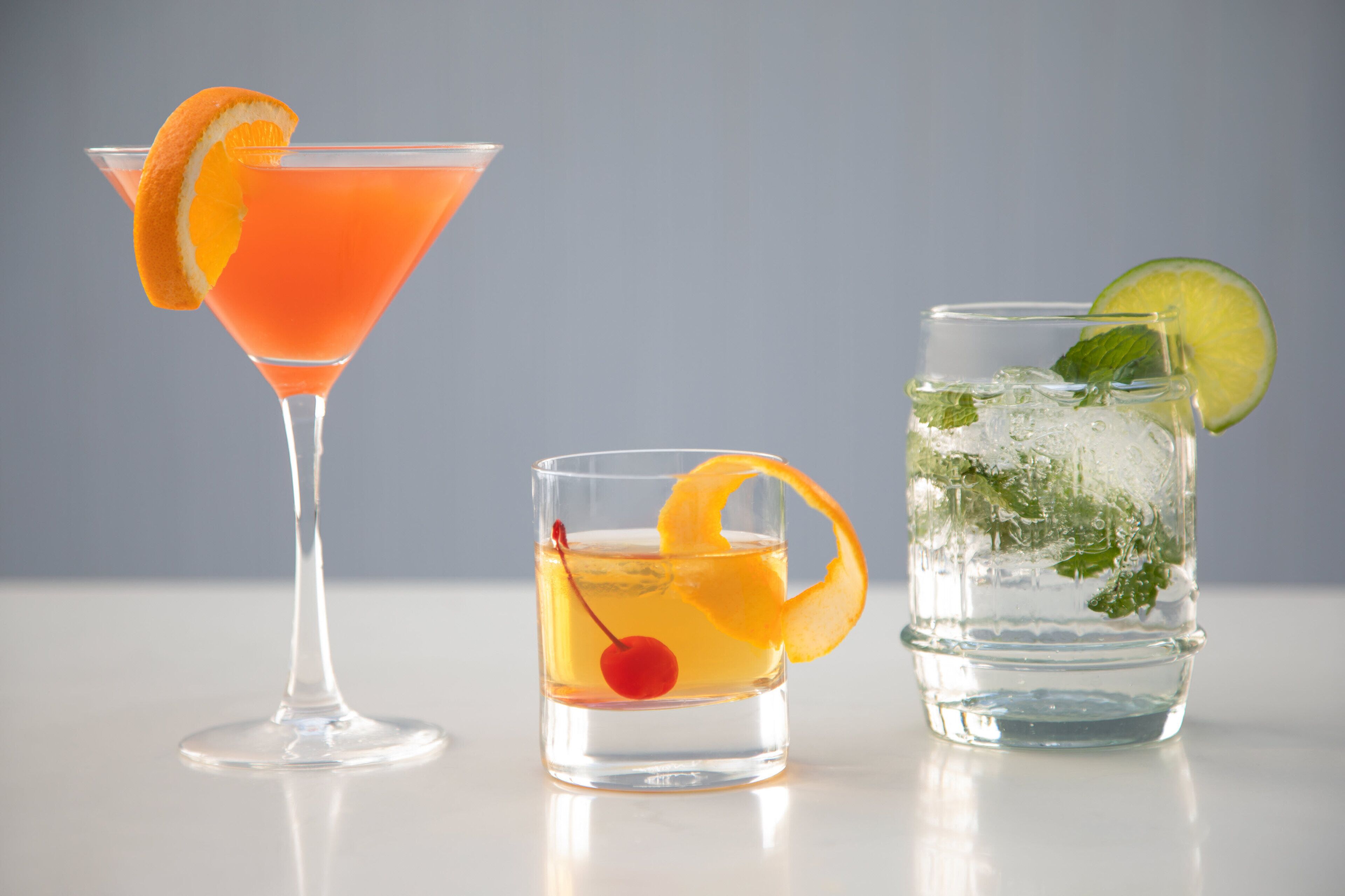 Three different types of drinks in clear glasses.